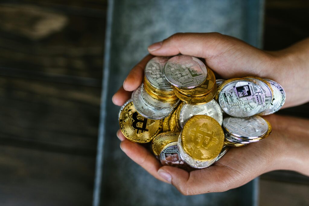 pexels-photo-8369770-8369770 A close-up of hands holding various cryptocurrency coins, representing digital finance.